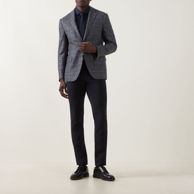 Model wearing Corneliani multi check wool jacket, styled with navy trousers and dark shirt, paired with black leather shoes.