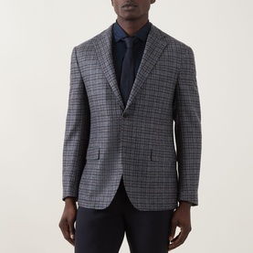 Model wearing Corneliani wool jacket in multi check, styled with navy tie and trousers. Single-breasted, notch lapel, two-button front.