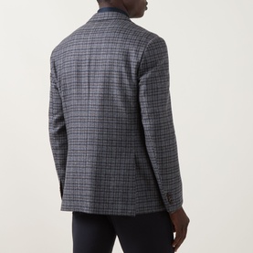 Model wearing Corneliani wool jacket in multi grey check, rear view, styled with dark trousers
