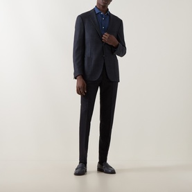 Model wearing Corneliani navy virgin wool jacket, styled with matching trousers, blue shirt and black leather shoes.