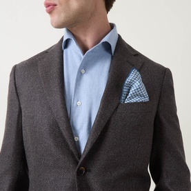 Model wearing Corneliani Hopsack Single-Breasted Blazer in brown wool blend, styled with light blue shirt and checked pocket square.