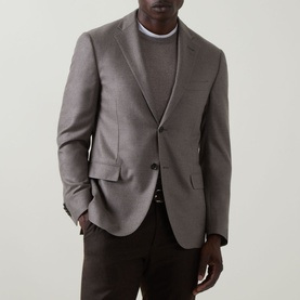 Model wearing Corneliani stone wool-cashmere blazer with two-button front, styled with grey crew-neck and dark trousers.