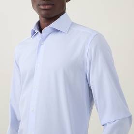 Model wearing Corneliani blue single cuff regular fit formal shirt in 100% cotton, showing collar and button placket detail.