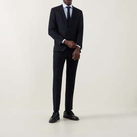 Model wearing Corneliani blue single cuff regular cotton formal shirt, styled with navy suit, tie, and black leather shoes.