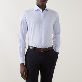 Model wearing Corneliani blue cotton formal shirt, single cuff regular fit, styled with dark trousers and brown leather belt.