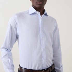 Model wearing Corneliani blue stripe single cuff regular fit cotton formal shirt with spread collar, styled with dark trousers