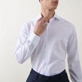 Model wearing Corneliani Poplin Polkadot Formal Shirt in white, long sleeves, pointed collar, structured cuffs, paired with navy trousers