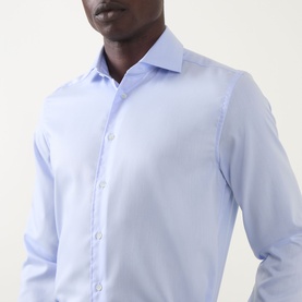 Model wearing Corneliani blue single cuff regular fit cotton formal shirt, close-up showing spread collar and button placket detail.