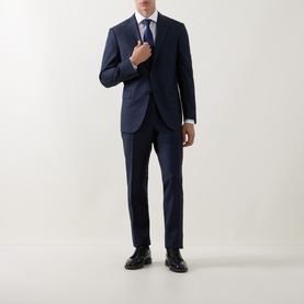 Model wearing Corneliani Micro-Weave Two-Piece Suit in navy, styled with white shirt and blue tie, black leather shoes.