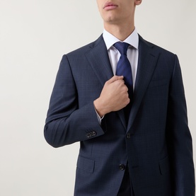 Model wearing Corneliani Micro-Weave Two-Piece Suit in navy, single-breasted jacket with notch lapel, styled with white shirt and blue tie.