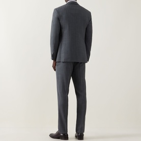 Model wearing Corneliani grey pinstripe wool suit, back view, tailored jacket and trousers, styled with brown leather shoes.