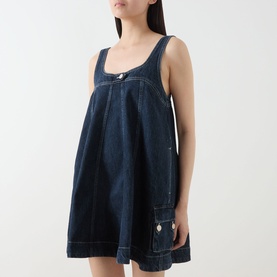 Model wearing Damson Madder Immy Denim Mini Dress in blue, featuring square neckline, adjustable straps, pleated detail and patch pocket