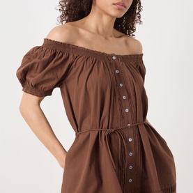 Model wearing Damson Madder Jayne Embroidered Mini Dress in Chocolate with off-shoulder shirred neckline, puff sleeves and button front detail