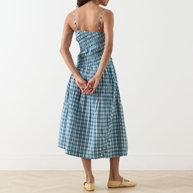 Model wearing Damson Madder Lyra Panelled Tomboy Check Dress in blue check cotton, midi length with flared skirt and button placket. Styled with
