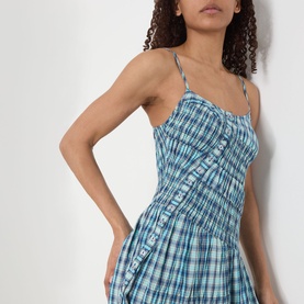 Model wearing Damson Madder Lyra Panelled Tomboy Check Dress in blue check with adjustable straps and shirred asymmetric panels