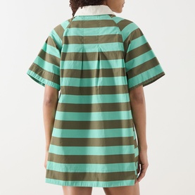 Model wearing Damson Madder Maggie Polo Dress in green and khaki bold two-tone stripes, short sleeves, flared mini length, rear view