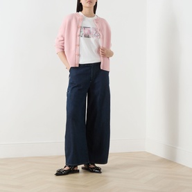 Model wearing Damson Madder Augusta Mid-Rise Straight Leg Jeans in Dark Indigo with wide-cut legs, styled with pink cardigan and white graphic tee.