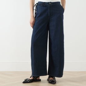 Model wearing Damson Madder Augusta Mid-Rise Straight Leg Jeans in dark indigo with frill tie waist detail, styled with black mary jane flats