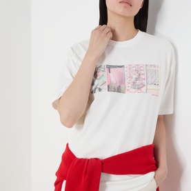 Model wearing Damson Madder off white cotton T-shirt with pink photographic graphic print, styled with a red tied sweatshirt at the waist.