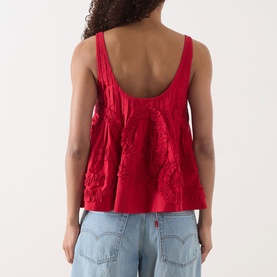 Model wearing Damson Madder Stella Ruffle Cami in red, showing scoop back, wide straps and tonal textured detail, styled with light blue jeans.