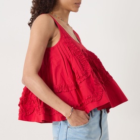 Model wearing Damson Madder Stella Ruffle Cami in red with scoop neckline, wide straps and flared hem, styled with light blue jeans.