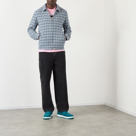 Model wearing BAPE Felt Logo Check Print Shirt in navy check, styled with pink tee, black trousers and teal trainers.