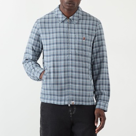 Model wearing BAPE Felt Logo Check Print Shirt in navy check, styled with black jeans. Features point collar, chest patch pocket and felt logo badge.
