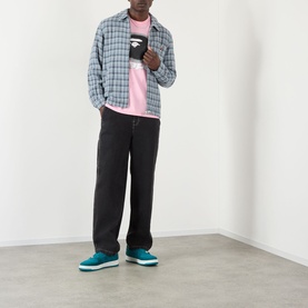 Model wearing BAPE Felt Logo Check Print Shirt in navy check, styled with pink tee, black wide-leg trousers and teal trainers.