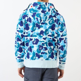 Model wearing blue camouflage zip-up hoodie with ribbed cuffs and hem, styled with grey joggers, rear view shown.