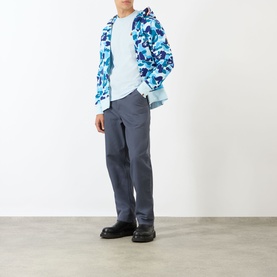 Model wearing blue camouflage zip-up hoodie jacket, styled with light blue tee, grey trousers and black shoes