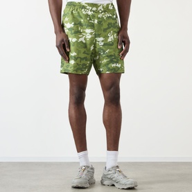 Model wearing BAPE Multi Pixel Camouflage Shorts in green pixel camo print with elasticated waist, styled with white socks and grey trainers.
