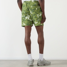 Model wearing BAPE Multi Pixel Camouflage Shorts in green pixel camo print, styled with white socks and grey trainers, rear view.