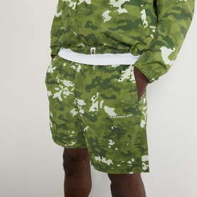 Model wearing BAPE Multi Pixel Camouflage Shorts in green pixel camo print with elasticated waist, styled with matching camo hoodie.