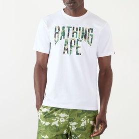Model wearing BAPE Camouflage NYC Logo T-Shirt in white with green camo logo print, styled with matching camo shorts