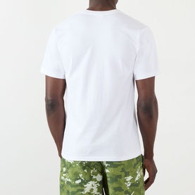 Model wearing BAPE Camouflage NYC Logo T-Shirt in white, back view, styled with green camo shorts. Round neck, short sleeves, straight hem.