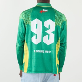 Model wearing BAPE Logo Football Jersey Long-Sleeved T-Shirt in green with number 93 back print and yellow graphic detailing.