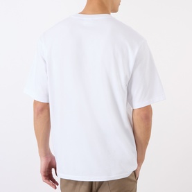 Model wearing BAPE Lighter Relaxed Fit T-Shirt in white, rear view, showing dropped shoulders, crew neck, and relaxed fit. Styled with beige trousers.