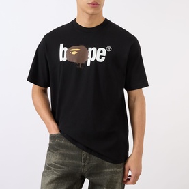 Model wearing BAPE Graffiti Logo Relaxed Fit T-Shirt in black with ape graphic, styled with distressed grey jeans
