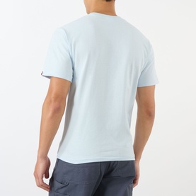 Model wearing BAPE One Point Logo T-Shirt in light blue, rear view, crew neck, short sleeves, paired with grey trousers