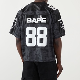 Model wearing BAPE Logo Football Jersey T-Shirt in black with number 88 and camo print, back view showing logo detail