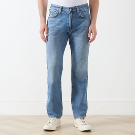 Model wearing Citizens of Humanity Elijah Straight-Leg Trousers in Shadow Blue, mid-rise, five-pocket styling, paired with white trainers