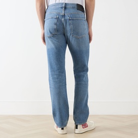 Model wearing Citizens of Humanity Elijah Straight-Leg Trousers in Shadow Blue, rear view showing logo patch and straight leg fit.