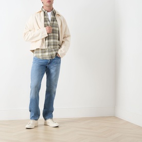 Model wearing Citizens of Humanity Elijah Straight-Leg Trousers in Shadow Blue, styled with cream jacket, plaid shirt and white trainers.