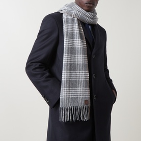 Model with Eleventy Logo Check Fringed Scarf in grey check with fringed edges and logo badge, styled over dark navy overcoat