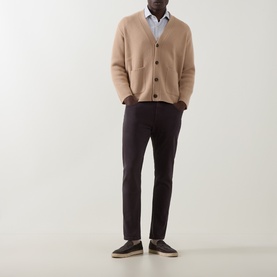 Model wearing Eleventy camel wool-cashmere cardigan with button front, styled with light blue shirt and dark brown trousers.