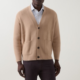 Model wearing Eleventy camel wool-cashmere cardigan with V-neck, button front, and patch pockets, styled with white shirt and dark trousers.