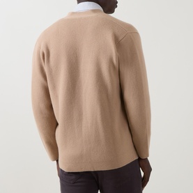 Model wearing Eleventy camel wool-cashmere cardigan, back view, styled with a white shirt and dark trousers.