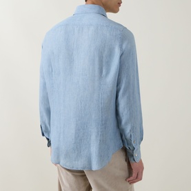 Model wearing Eleventy blue linen casual shirt, rear view, with button cuffs, styled with beige trousers.