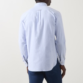 Model wearing Eleventy light blue cotton casual shirt, rear view showing back pleat detail, styled with dark blue jeans