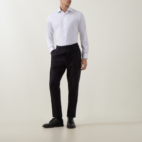 Model wearing Eleventy white casual shirt with navy tailored trousers and black leather shoes.